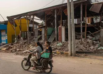 On 31 March 2025, two women are seen riding a motorcycle, passing by a collapsed building in Sagaing, Myanmar, following the 7.7-magnitude earthquake that struck Mandalay on 28 March. Photo: UNICEF/UNI771892/Htet