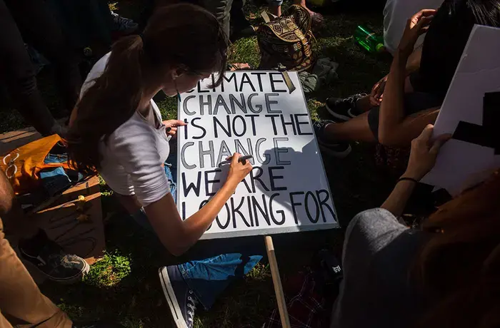 A young woman in New York prepares a protest sign as part of the youth-lead global Climate Strike in September 2019.   Photo: UN Women/Amanda Voisard