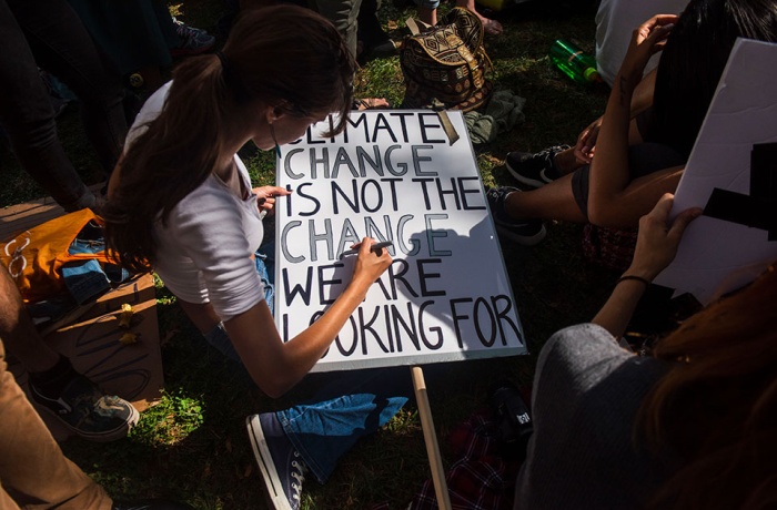 A young woman in New York prepares a protest sign as part of the youth-lead global Climate Strike in September 2019.   Photo: UN Women/Amanda Voisard