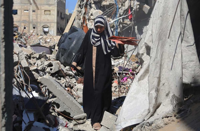 A view of a woman in Gaza walking amid the rubble