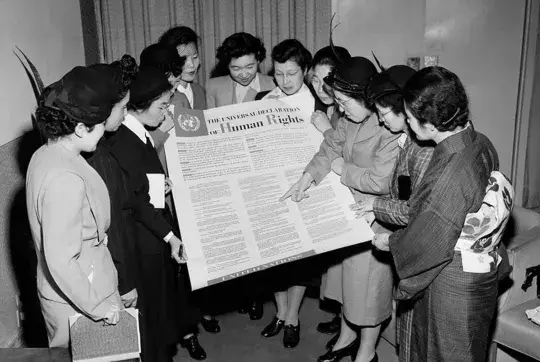 a group of women look at the declaration of human rights