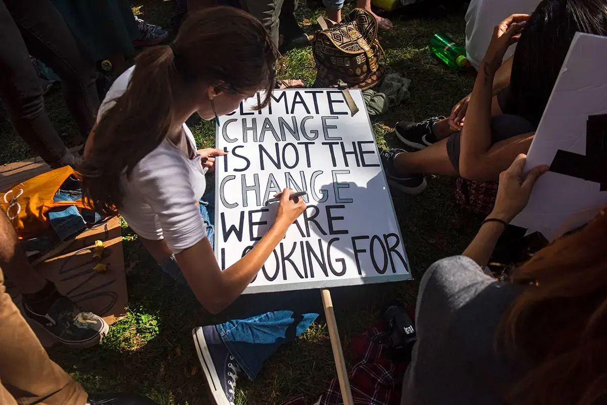 During a demonstration in downtown New York as part of the youth-lead global #ClimateStrike in 2019, a participant creates a sign that reads "Climate Change is not the Change We Are Looking For."