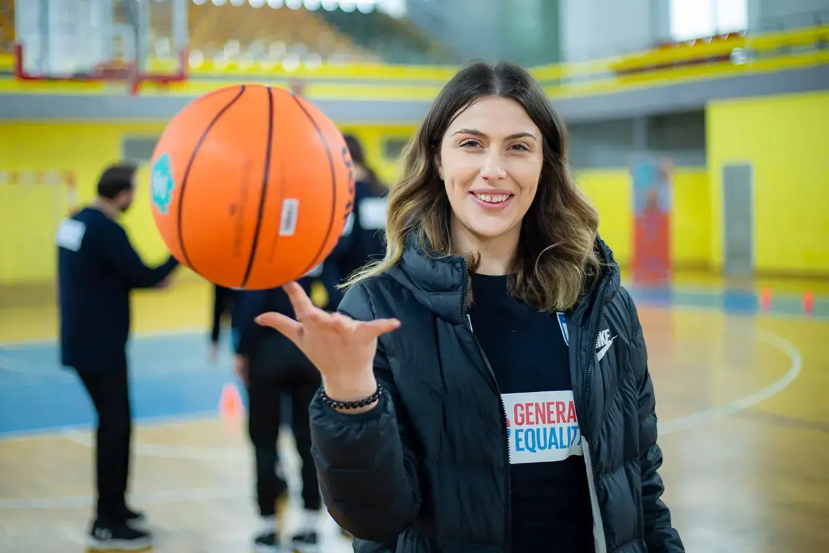 A girls holds a basketball in the in the city of Gjakova, in western Kosovo (under UNSCR 1244) to mark International Women's Day with UN Women.