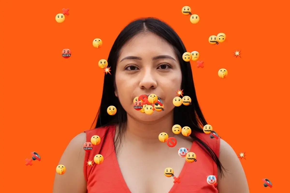 A woman is silenced by digital abuse. In the photo a woman's mouth is covered by hateful emojis. Photo: UN Women.